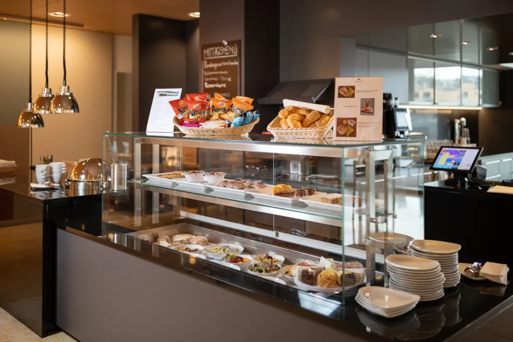 Eine modern gestaltete Theke im Café Soleil mit frischen Salaten, Gebäck und Snacks.